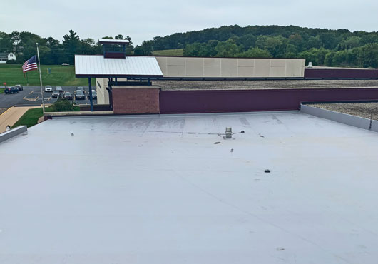 Borche Roofing Professionals, Inc. maintains the roofs for the Hortonville Area School District. In this photo, Borsche removed a ballasted rubber roof and installed a gray TPO RhinoBond system.